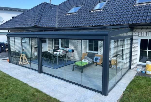 Große verglaste Glasoase mit Sitzgruppe